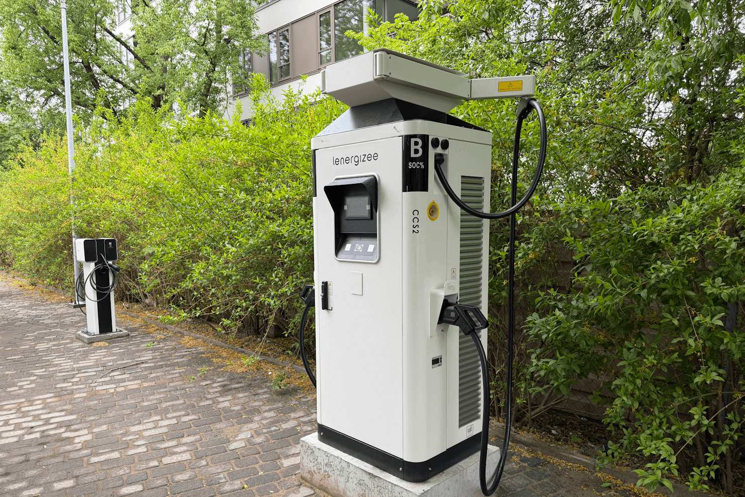Szybka stacja ładowania DC Lenergizee CCS2 przy parkingu, przykład rozwoju infrastruktury ładowania pojazdów elektrycznych w Polsce